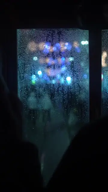 Mưa đọng trên kính tàu điện đêm